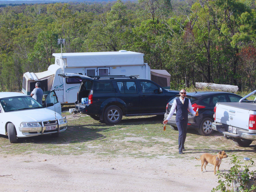A lively outdoor social event with people engaged in activities, set against a picturesque nature backdrop.