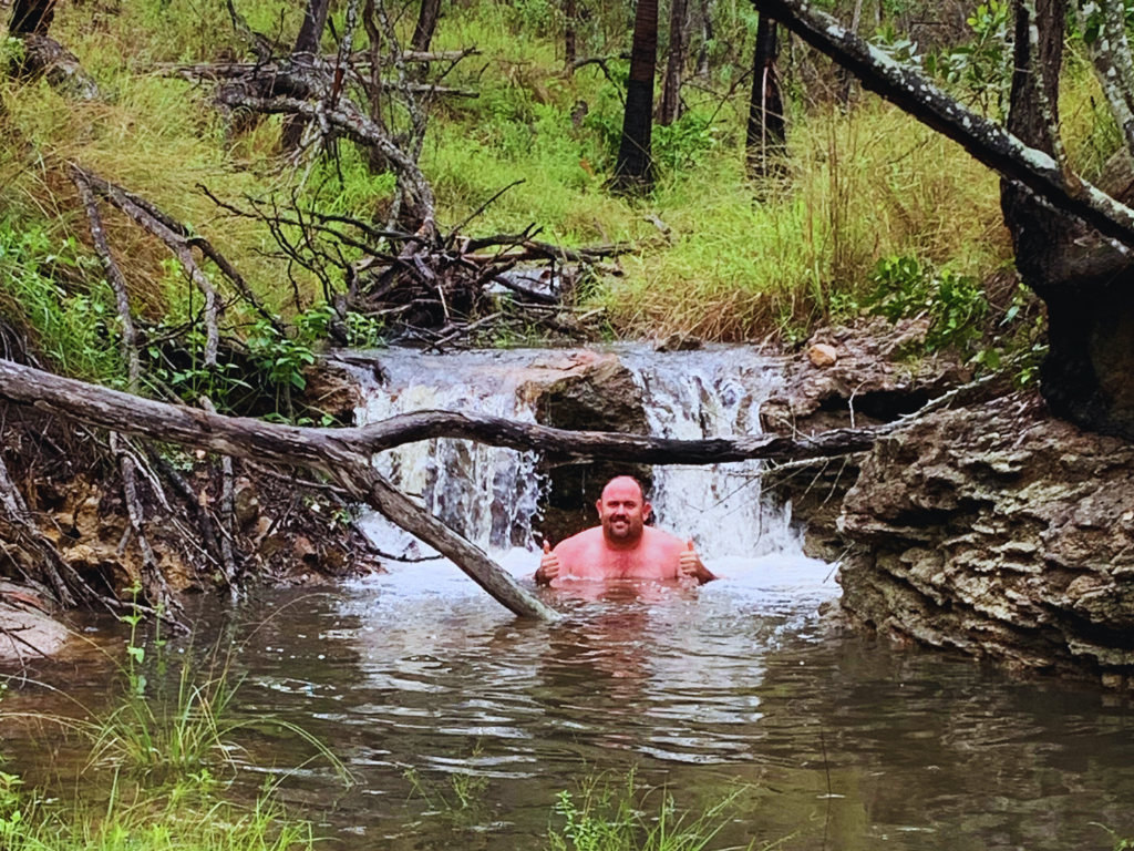 A camper enjoying the natural dam in the Campsite.